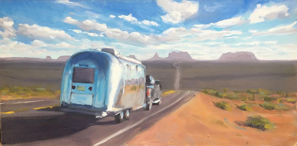 vintage airstream heading towards monument valley at sunset